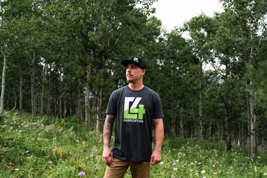 Caleb Rupp, Founder of C4 Fabrication standing in a forested area.