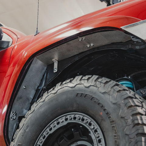 Low-angle view of the high clearance fender liner inside a trimmed fender flare on a 2nd Generation Tacoma.