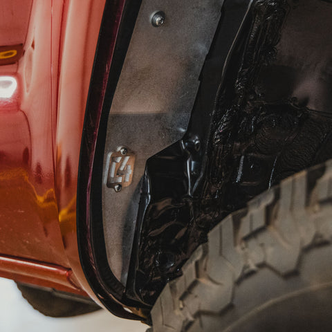View of the bottom rear portion of the C4 High Clearance Fender Liner kit with the C4 logo. 