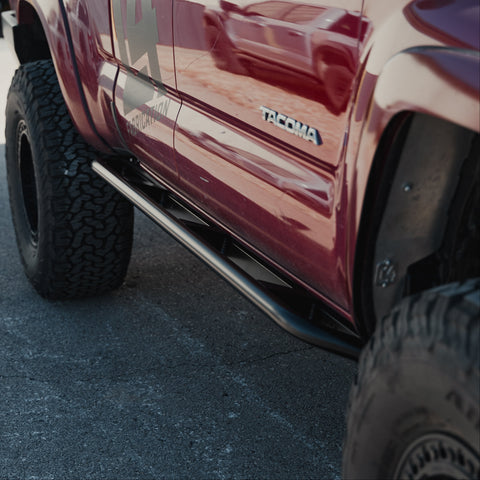 Rock Runner minimalist slider installed on a red Toyota Tacoma.
