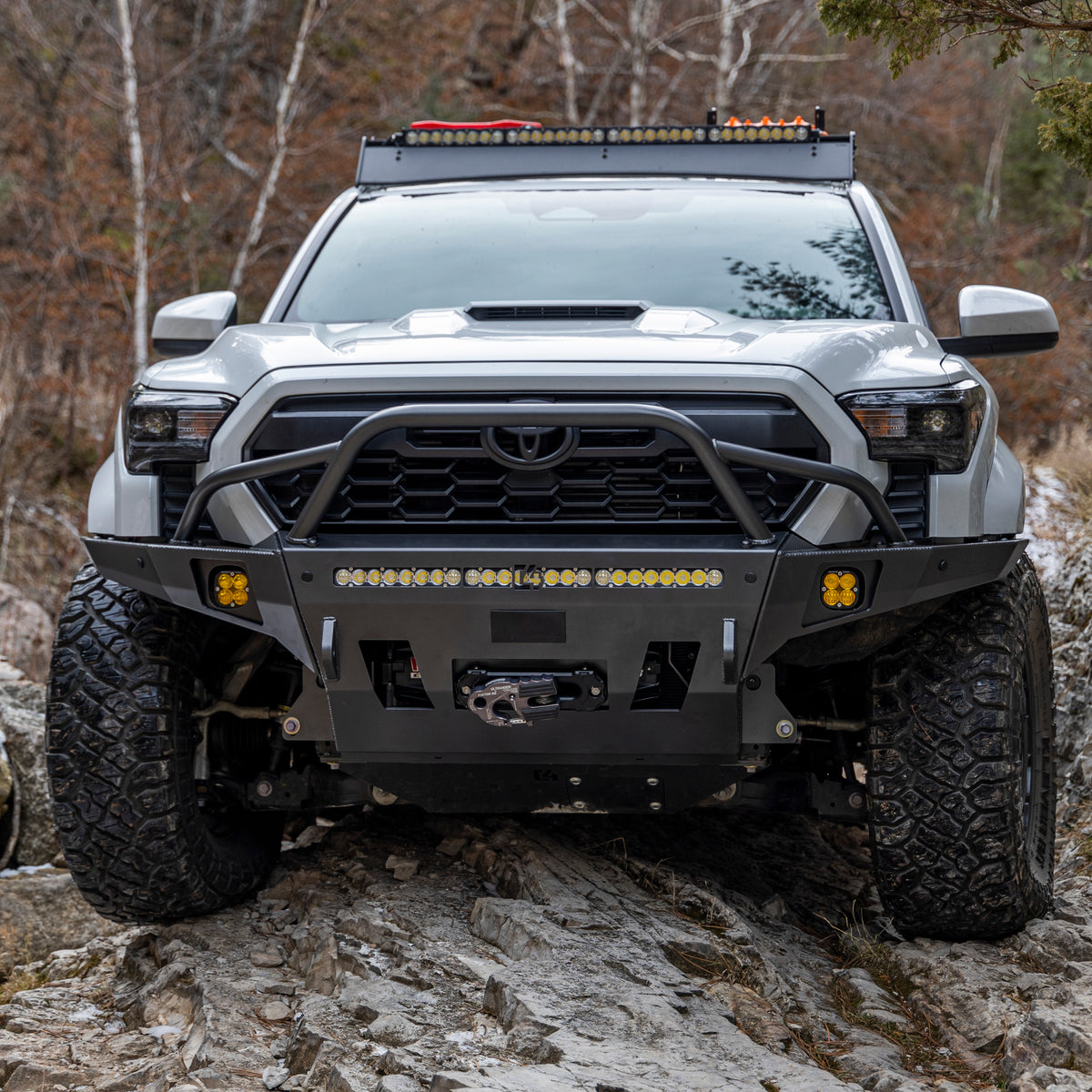 Straight on photo of a 4th Gen Tacoma equipped with a C4 Overland bumper with mid-height bull bar and tube gussets.