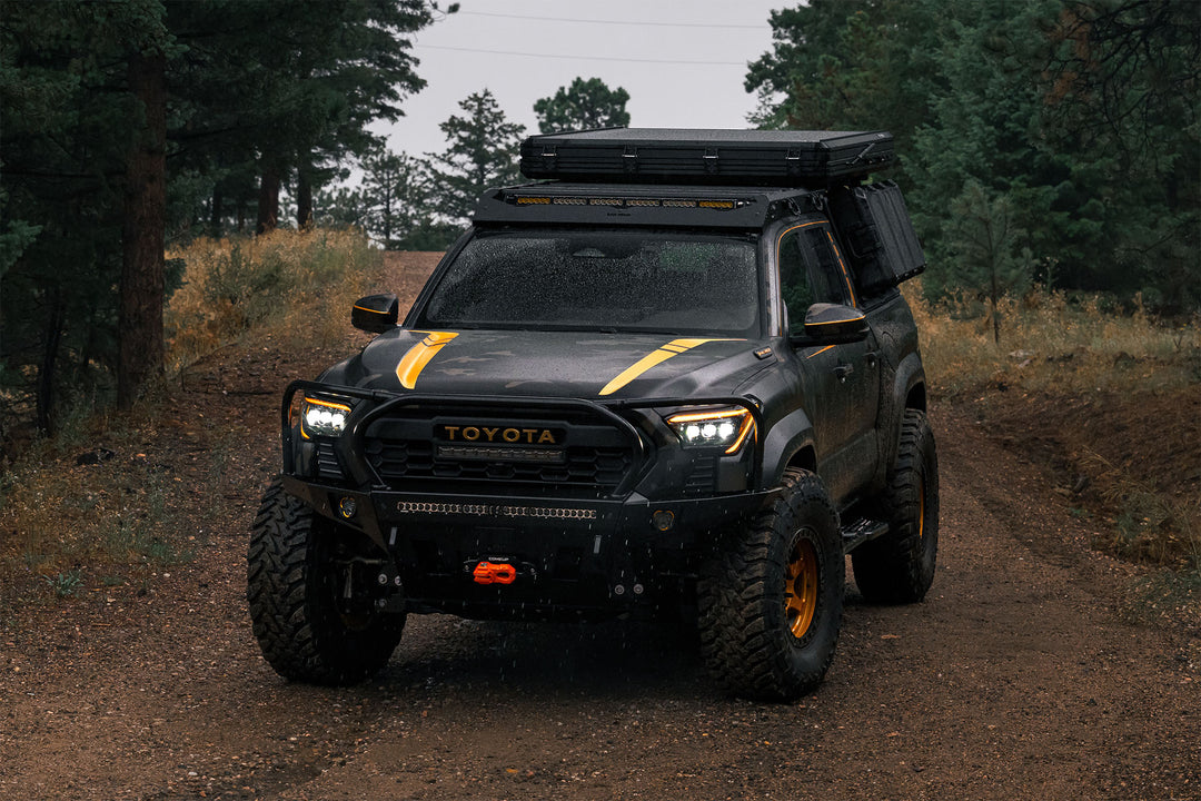 4th Gen Tacoma with overland bumper and full height hoop. Rainy weather on forest road.