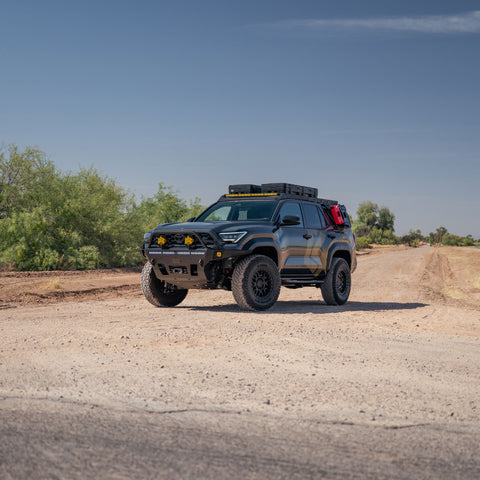 Farm road with our fully built-out 6th gen 4Runner with C4 Fabrication Overland Series Front Bumper, Roof Rack, Sliders, Molle Panels, and skid plates.