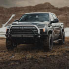 Black Toyota 2022 Tundra equipped with a C4 Overland front winch bumper with mid-height bull bar with tube gussets.