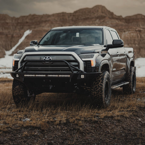 Black Toyota 2022 Tundra equipped with a C4 Overland front winch bumper with mid-height bull bar with tube gussets.