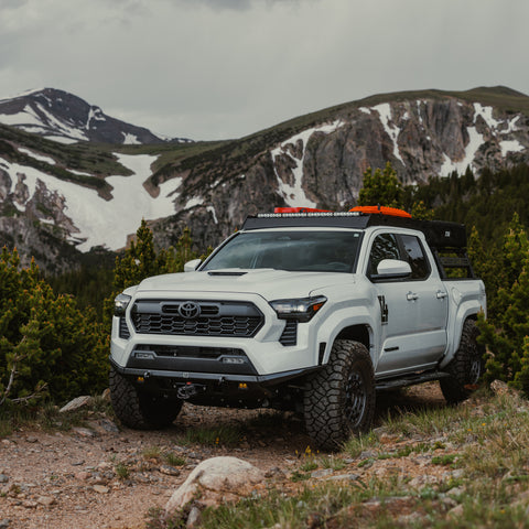 4th Generation Tacoma on a mountain road and equipped with a roof top tent, Sherpa roof rack and the C4 Lo-Pro front winch bumper.