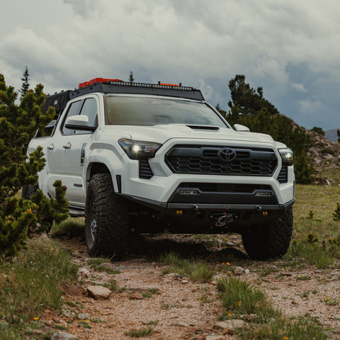 White Tacoma in the mountains with a C4 Lo-Pro winch bumper.