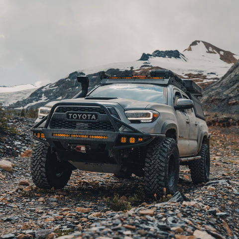 Tacoma on a shale road fully equipped for adventure and with a C4 Hybrid bumper on front.