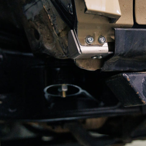 View into the rear of the front wheel well on a 5th Gen 4Runner showing the bottom mount for the High Clearance Fender Liner kit and in the background, the C4 Body Mount Relocation Kit. 