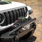 Front view of a white Jeep with DV8 Xtract 12k Synthetic Rope Winch on a natural background