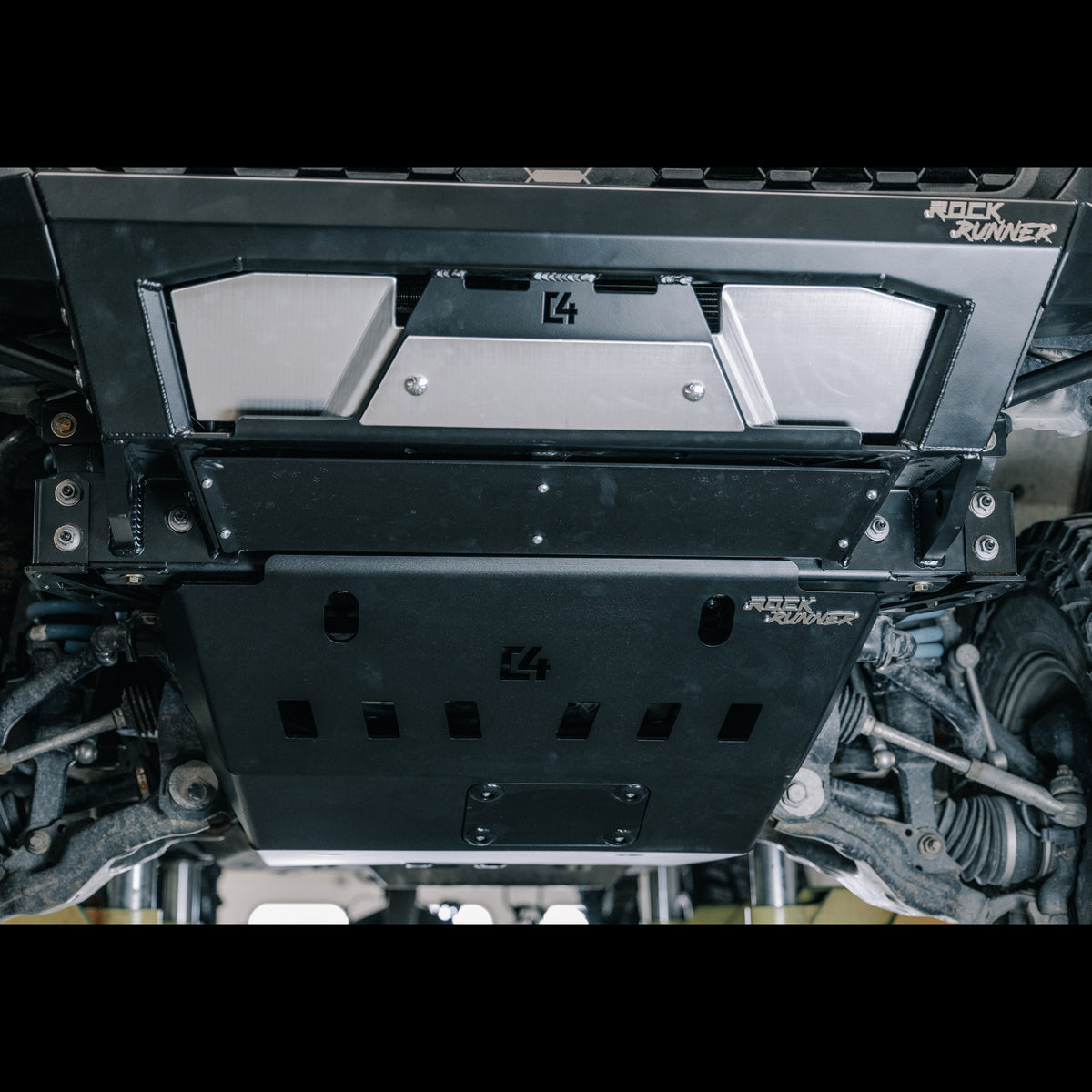 Close up view from underneath the front of a 3rd Gen Tacoma with the Rock Runner bumper and skid plate installed, showing the smooth transition between the two and the extreme approach angle it results in.