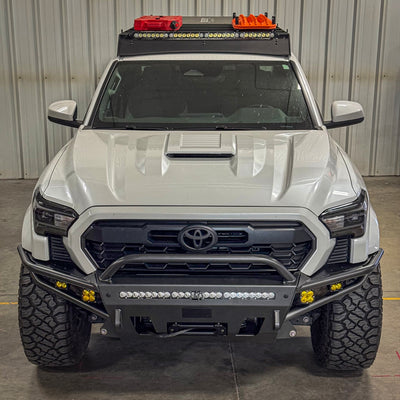 High angle photo looking down at a white Toyota Tacoma with the C4 Hybrid front winch bumper and a Sherpa roof rack installed.