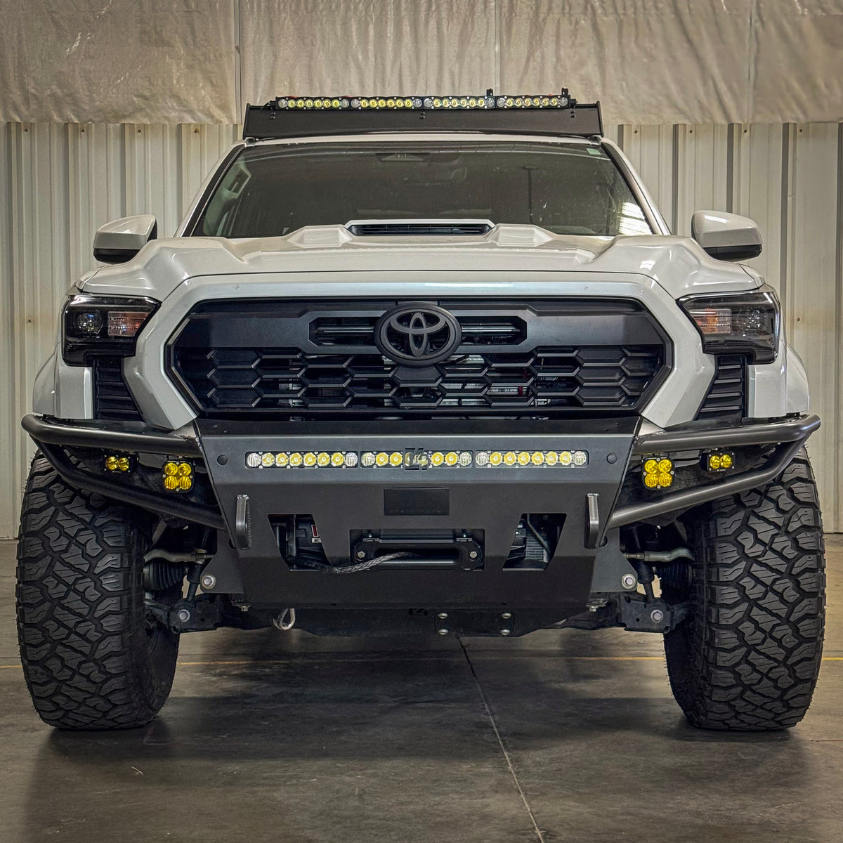 C4 Hybrid front bumper for the 2024+ Tacoma installed on a white truck with 30" lightbar and four auxiliary lights installed.