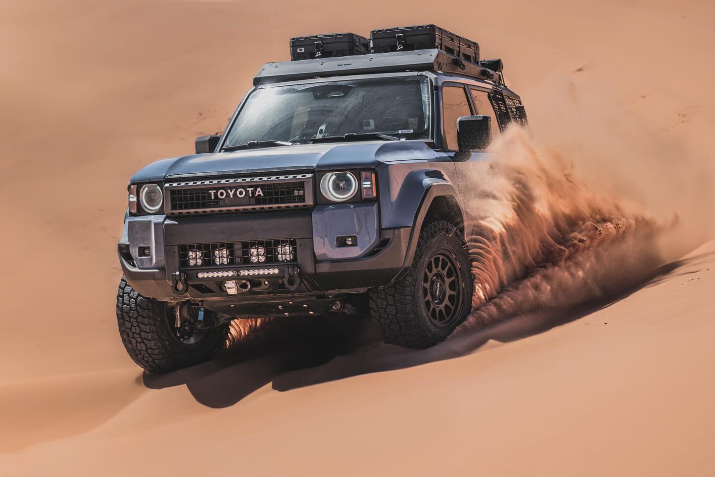 Toyota Land Cruiser driving through sand dunes