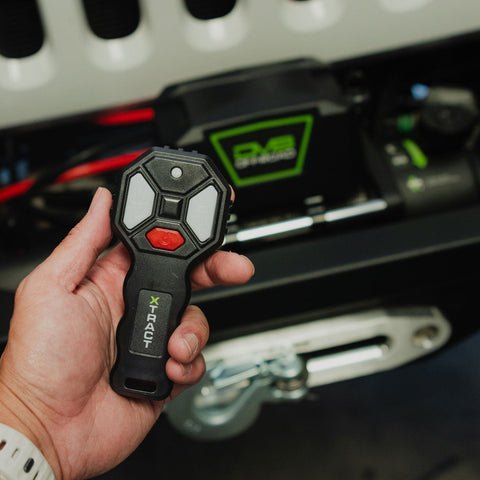 Person holding wireless remote with 150 foot range on the DV8 Xtract 9.5k Synthetic Rope Winch