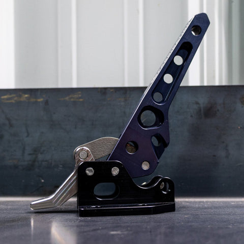 Side view of the C4 billet swing arm latch sitting on a table. 