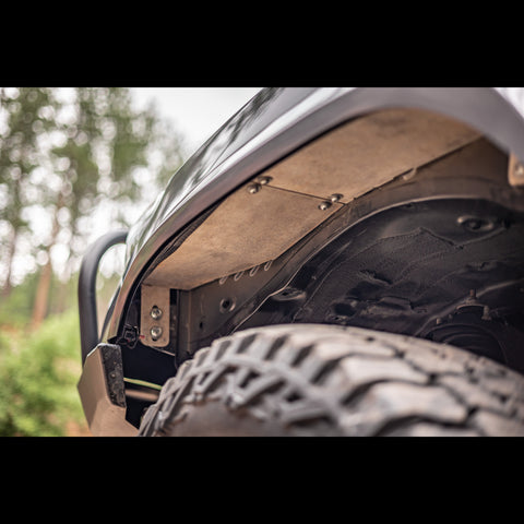 View up underneath the front of the Overized Tire Fitment Kit and its High Clearance Fender Liners from C4 Fabrication.