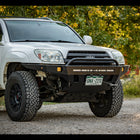Passenger side angled front view of a white V8 4Runner with a C4 bumper installed.