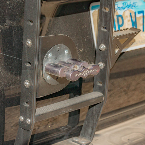 Close-up quartering view of the C4 bracket equipped with a RotopaX brand pack mount for the Summit hatch ladder showing how the bracket attaches to the available mounting holes on the ladder uprights.