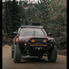 Rolling photo of a 4th Gen 4Runner driving at speed down a mountain road, equipped with a Sherpa roof rack, 35" tires and a C4 Fabrications Overland winch bumper. 
