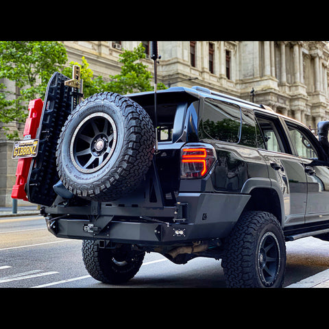 Low-angle quartering view of the C4 Fabrications rear bumper for 2010-2024 4Runners equipped with dual swing-outs for spare tire and accessories. 