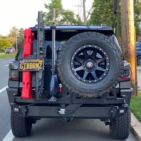 4Runner parked along a city street and equipped with a C4 Fabrications steel rear bumper with dual swing-outs for spare tire, high-lift jack, MaxTrax, RotoPax and a relocated license plate.