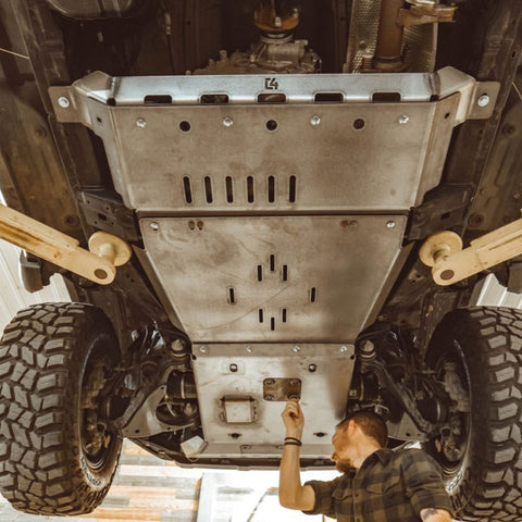 View from underneath and to the rear of a full skid set from C4 fabrication that shows detail of the transfer case skid crossmember. 