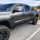 View of a grey four-door Tacoma with a set of C4 Sliders installed.