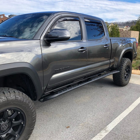 View of a grey four-door Tacoma with a set of C4 Sliders installed.