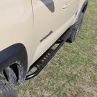 Top-down view of a set of powder coated C4 Sliders on a tan 4-door Tacoma.