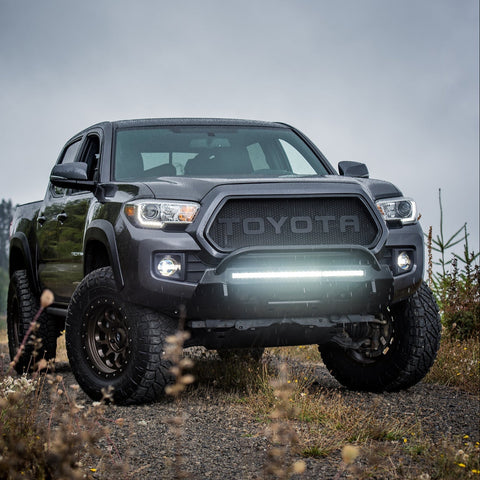 Grey four-door Tacoma with C4 Lo-Pro winch bumper installed with a light bar inside. 