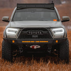 Straight on view of a Tan Tacoma with a roof rack and C4 Overland front winch bumper.