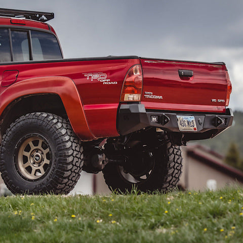 Low angle quartering view of the C4 Overland rear bumper on a red Tacoma.