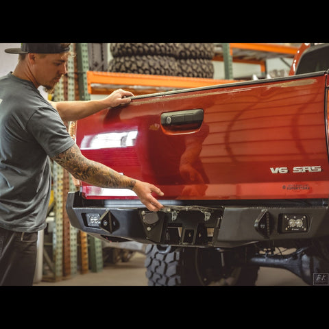 C4 owner Caleb Rupp demonstrating the hidden hitch on the C4 Overland rear bumper by pivoting up the license plate to reveal the receiver. 