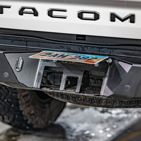 View of the concealed hitch that is employed by flipping up the license plate on the C4 Overland rear bumper for the Tacoma.