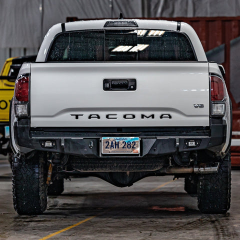 White Tacoma with a black powder coated C4 Overland rear bumper installed. 