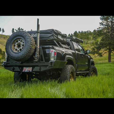 Wider view of a black Tacoma with the C4 high clearance bumper with spare tire swingout.