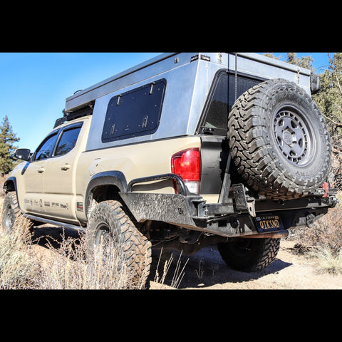 Tan four door Tacoma with a pop-top topper and the C4 High Clearance Rear Bumper.