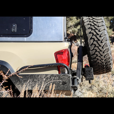 Side view of the C4 Overland High Clearance rear bumper with tire swing out on a Toyota Tacoma.