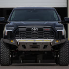 Straight-on view of a black 3rd Gen Tundra with a C4 Overland front bumper in raw steel. 