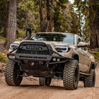 Tan Tacoma on a mountain trail with a C4 Hybrid bumper with full-height bull bar with tube gussets.