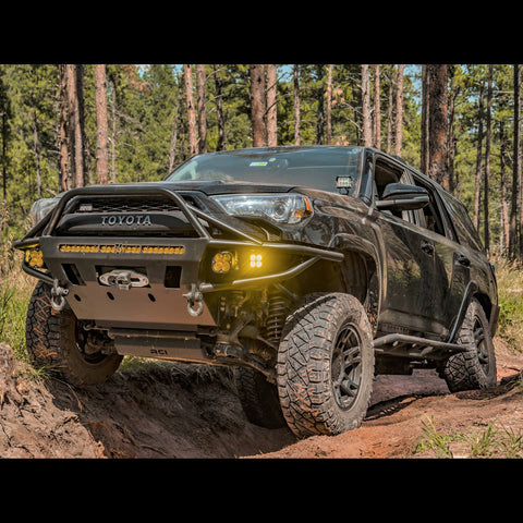 Black Toyota 4Runner spanning a dirt crevasse and equipped with the Hybrid tube/plate bumper manufactured by C4 Fabrication in Sturgis, SD.