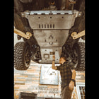 View from underneath and behind as the oil drain access panel is removed from the C4 full skid plates set for the 5th Generation 4Runner.