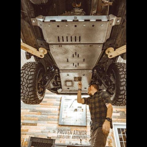 View from underneath and behind as the oil drain access panel is removed from the C4 full skid plates set for the 5th Generation 4Runner.